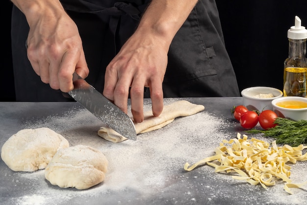 自家製麺を作るためのステップバイステップの説明。料理人が生地を切っています