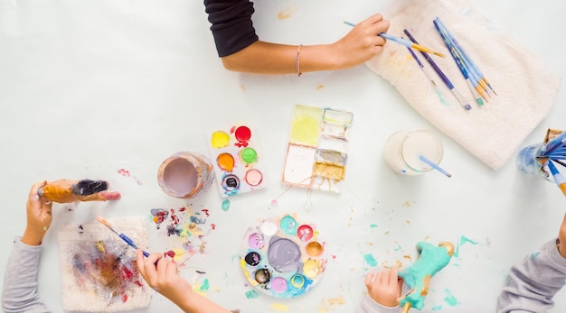 Step by step. Little girls painting paper mache unicorn with acrylic paint.