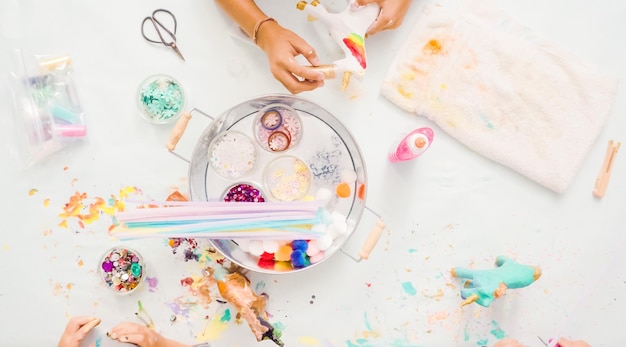 Step by step. Little girls painting paper mache unicorn with acrylic paint.