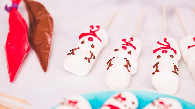 ステップバイステップ。マシュマロの雪だるまとトナカイをスティックホットチョコレートトッパーで作って、食べ物を贈りましょう。