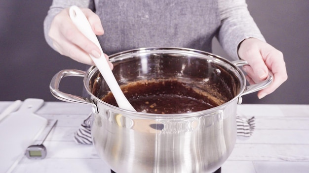 Step by step. Mixing ingredients in the cooking pot to make simple chocolate fudge.