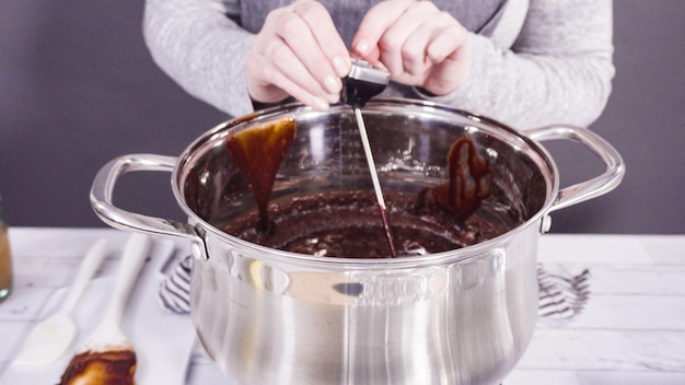 Step by step. Mixing ingredients in the cooking pot to make simple chocolate fudge.