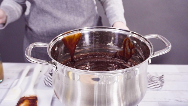 Step by step. Mixing ingredients in the cooking pot to make simple chocolate fudge.