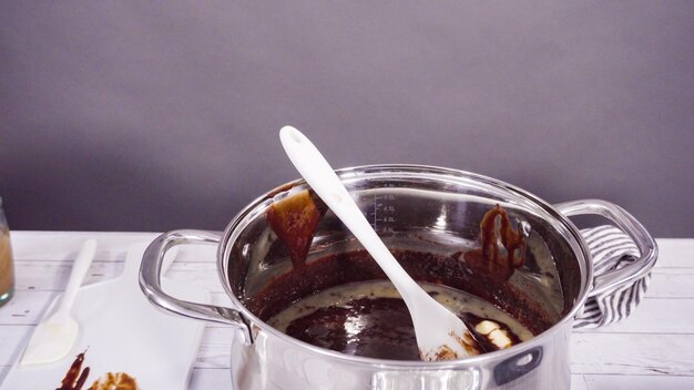 Step by step. Mixing ingredients in the cooking pot to make simple chocolate fudge.