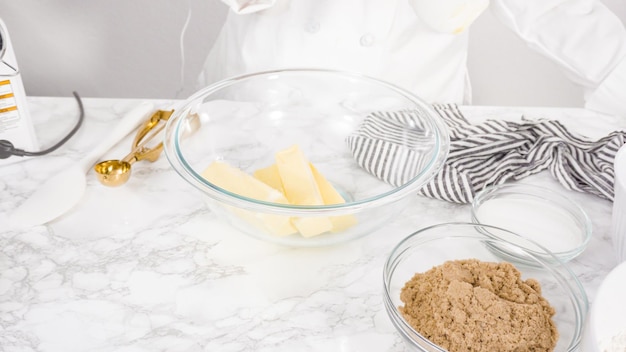 Step by step. Mixing ingredients in a glass bowl to make chocolate chip cookies.