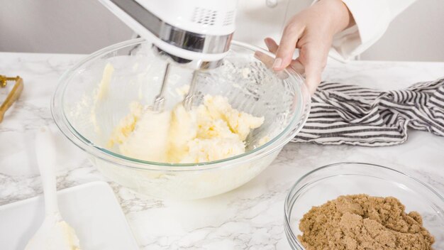 Step by step. Mixing ingredients in a glass bowl to make chocolate chip cookies.