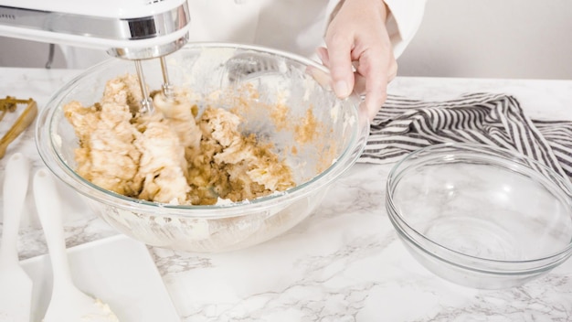 Step by step. Mixing ingredients in a glass bowl to make chocolate chip cookies.