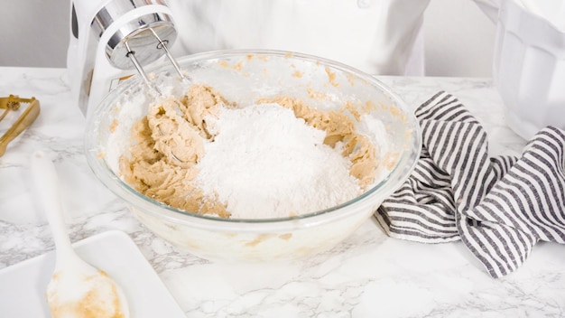 Step by step. Mixing ingredients in a glass bowl to make chocolate chip cookies.