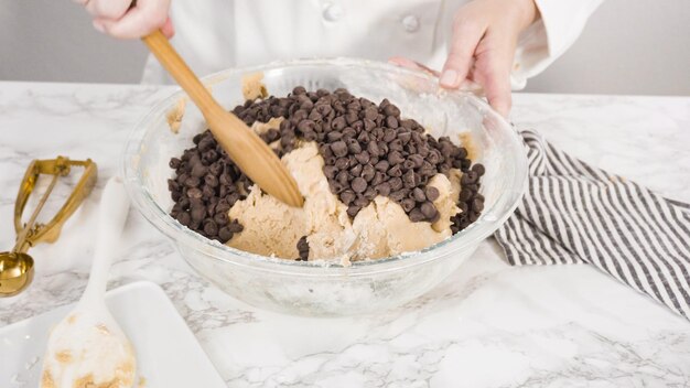 Step by step. Mixing ingredients in a glass bowl to make chocolate chip cookies.