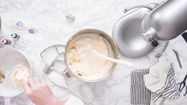 Step by step. Mixing ingredients in standing kitchen mixer to make buttercream frosting.