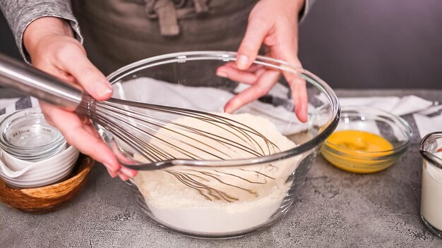 Step by step. Mixing ingredients together in glass mixing bowl for spicy jalapeno cornbread muffins.