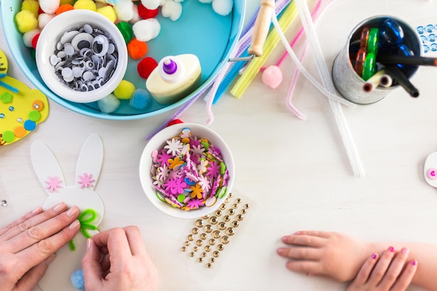 Step by step. Mother and daughter decorating Easter Bunnies.