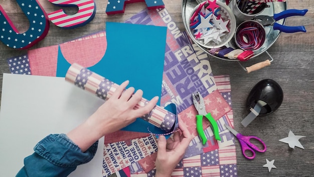 Photo step by step. mother and daughter making paper firecrackers for july 4th celebration.