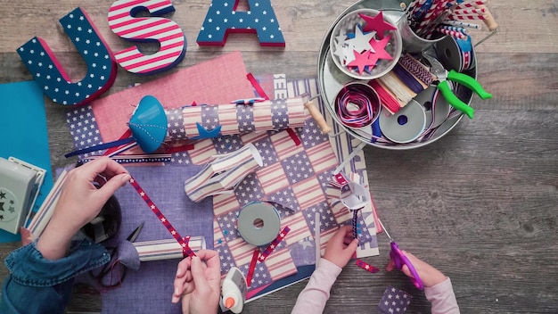 Step by step. Mother and daughter making paper firecrackers for July 4th celebration.