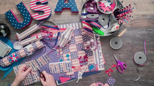 Step by step. mother and daughter making paper firecrackers for
july 4th celebration.