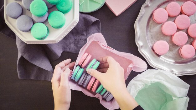 Step by step. Packaging french macarons into gift boxes.