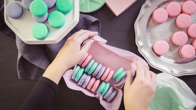 Step by step. Packaging french macarons into gift boxes.