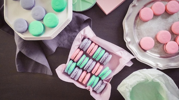 Step by step. Packaging french macarons into gift boxes.