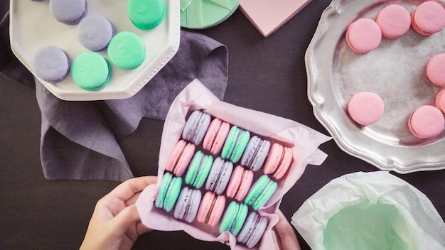 Step by step. Packaging french macarons into gift boxes.