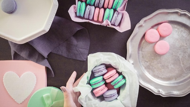 Step by step. Packaging french macarons into gift boxes.