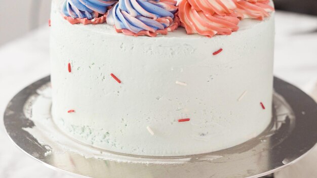 Step by step. Placing color sprinkles on the sides of round three-layer vanilla cake.