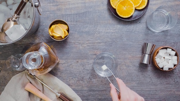 Step by step. Preparing Bourbon old fashioned cocktail at home bar.