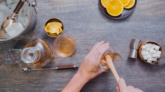 Step by step. Preparing Bourbon old fashioned cocktail at home bar.