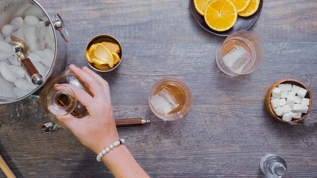 Step by step. Preparing Bourbon old fashioned cocktail at home bar.