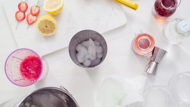 Step by step. Preparing Kentucky kiss bourbon cocktail with fresh organic strawberries.