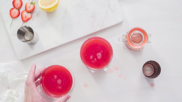 Step by step. Preparing Kentucky kiss bourbon cocktail with fresh organic strawberries.