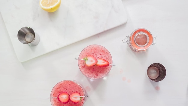 Foto passo dopo passo. preparazione del cocktail kentucky kiss bourbon con fragole fresche biologiche.