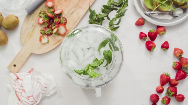 Step by step. Preparing organic infused water in glass beverage drink dispenser.