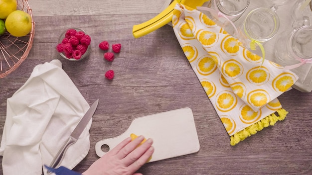 Step by step. Preparing raspberry lemonade with fresh lemons and raspberries in drinking mason jars.