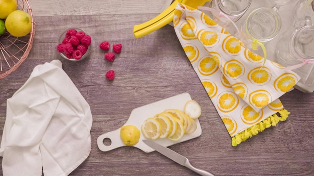 Step by step. Preparing raspberry lemonade with fresh lemons and raspberries in drinking mason jars.