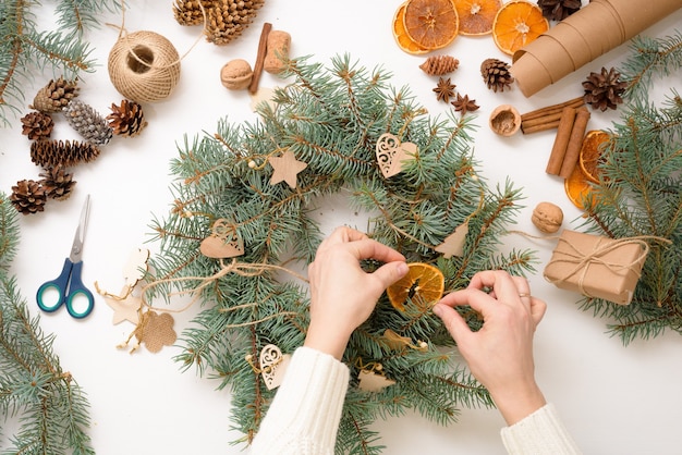 Step-by-step process of making Christmas tree wreath at home from spruce branches