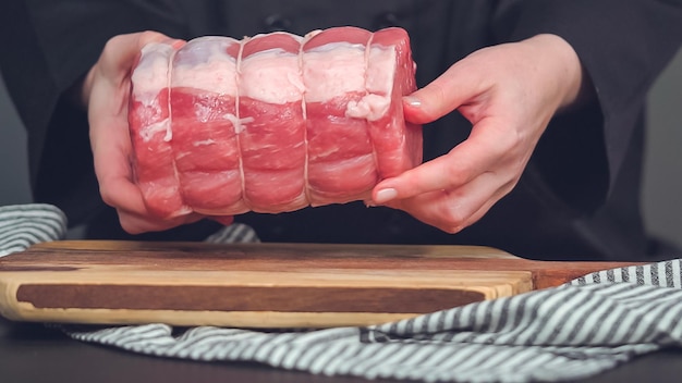 ステップバイステップ。スパイスを使った木のまな板の上で生の骨なしポークロースト。