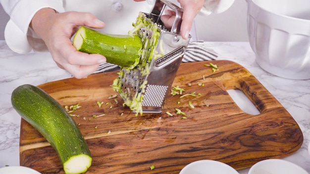 Step by step. Shredding organic zucchini to make zucchini cakes.