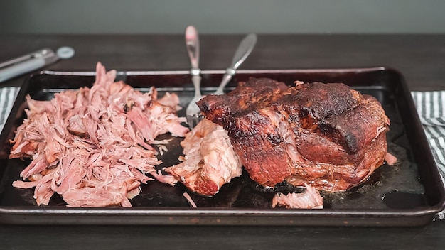 Step by step. Shredding pork roast shoulder with two forks.