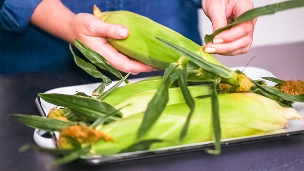 Step by step. Shucking fresh organic corn to make mexican corn salad.