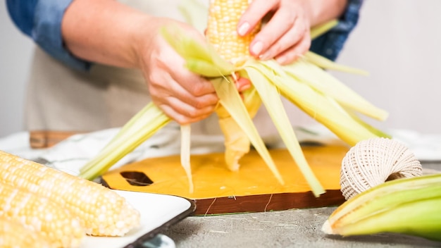 Step by step. Shucking organic corn to make Mexican corn on the cob Elote.