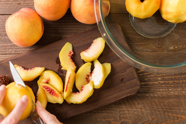 Step by step. Slicing organic peaches for peach cobbler.