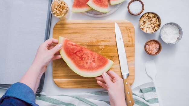 Step by step. Slicing watermelon into cubes for preparing chocolate covered watermelon bites.