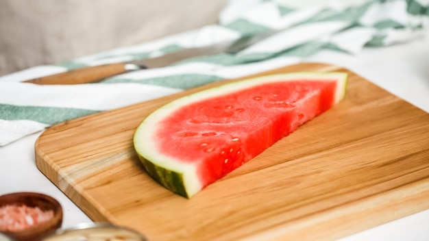 Step by step. Slicing watermelon into cubes for preparing chocolate covered watermelon bites.