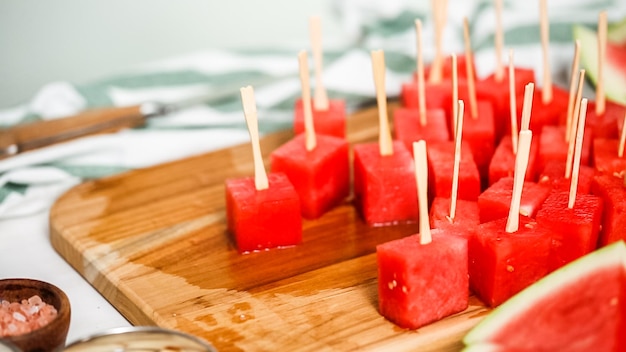 Step by step. Slicing watermelon into cubes for preparing chocolate covered watermelon bites.