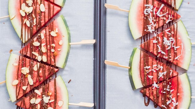 Step by step. Watermelon wedges garnished with chocolate and sea salt  on the stick on baking sheet.