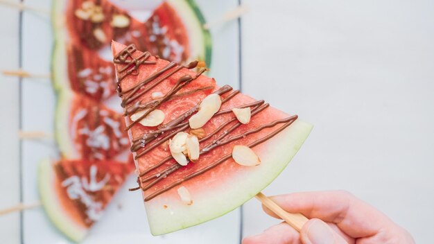 Step by step. Watermelon wedges garnished with chocolate and sea salt  on the stick on metal serving tray.