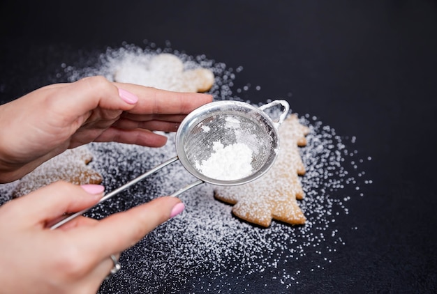 Photo step  of  powdered sugar scattered on a black stone countertop