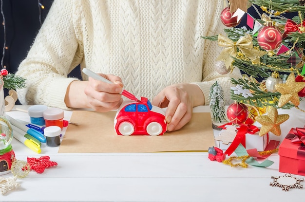 クリスマスの装飾のための段階的な写真の説明 女の子が石膏マシンをペイントします ステップ 3 フェルトペンで体に色を付けます