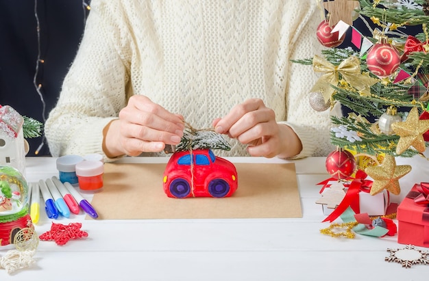 Istruzioni dettagliate per la foto per l'arredamento di natale una ragazza dipinge una macchina per intonaco passaggio 7 lega un albero di natale al tetto