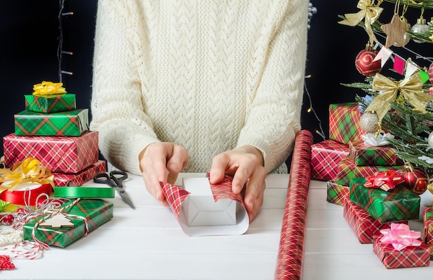 写真 クリスマスプレゼントをラッピングするためのステップバイステップの写真手順 ステップ 1 ギフトをラッピングペーパーでラッピングするプロセス